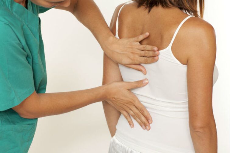 O médico examina as costas con dor debaixo do omóplato esquerdo
